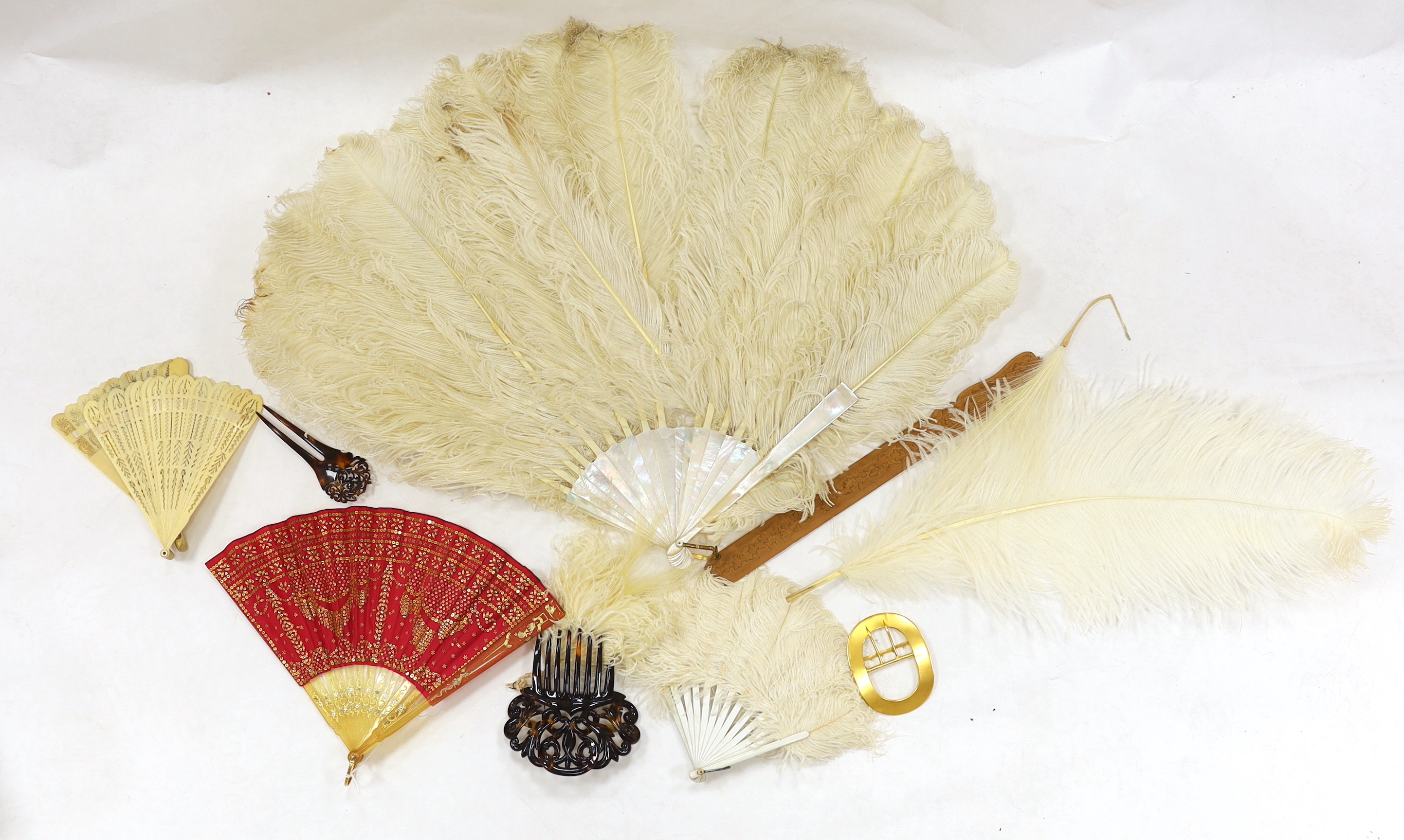 A Regency sequin and horn fan, a bone brise fan, a large white feather fan and a similar miniature fan and hat ornament two hair combs, etc